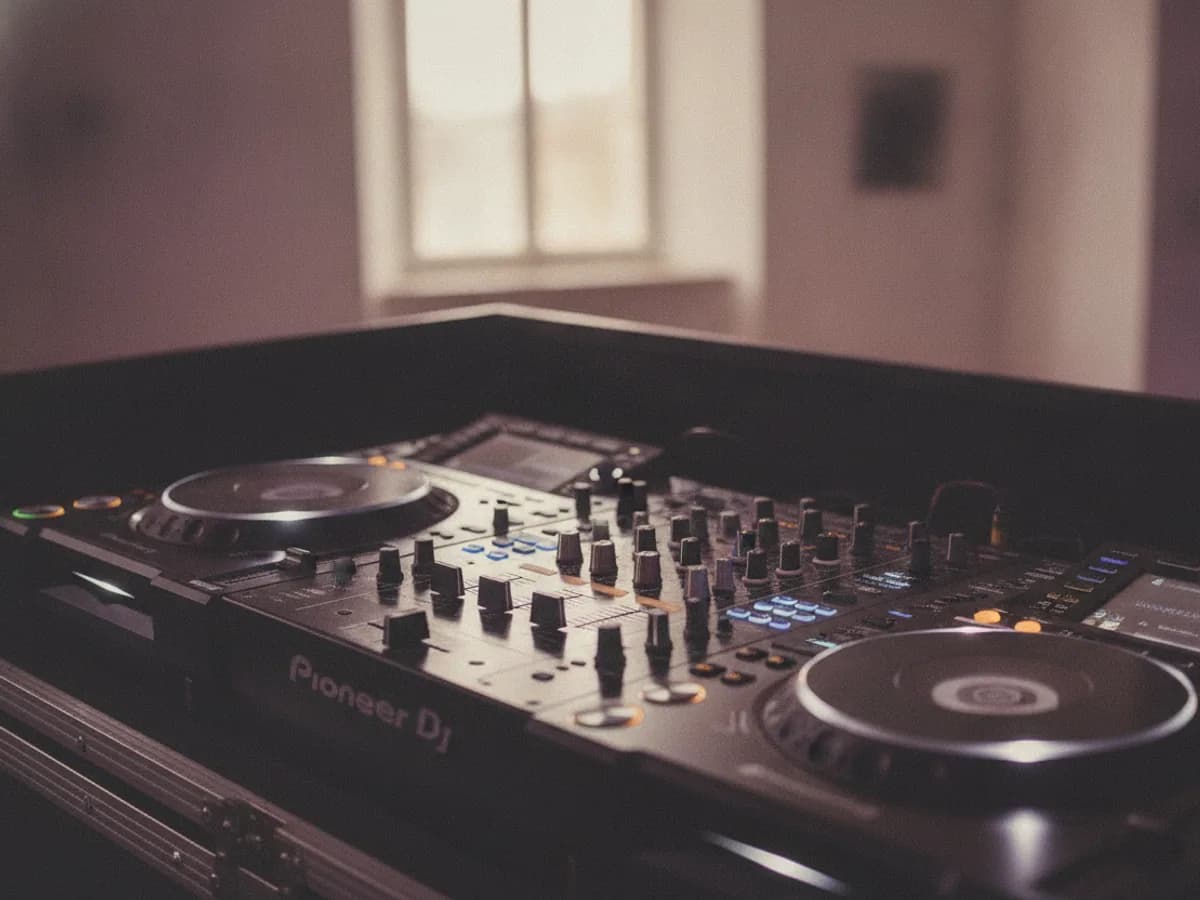 Nahaufnahme eines DJ-Mixers mit farbigem Bühnenlicht