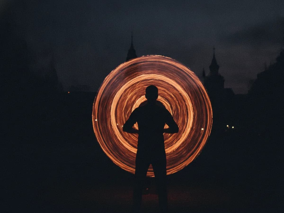 Silhouette einer Feuershow-Performerin bei einer Abendveranstaltung im Freien